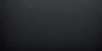 The primary subject of the image is a black background. The setting is a dark room, and the visual style is a black and white photo. The colors and mood of the image are dark and moody, creating a sense of mystery or drama.