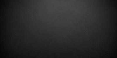 The primary subject of the image is a black background. The setting is a dark, empty space with no visible objects or elements. The visual style is a black and white photo, which gives the image a classic and timeless appearance. The colors and mood are predominantly dark and moody, creating a sense of mystery and depth.