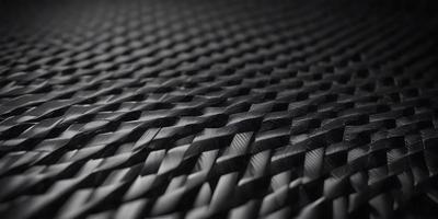 The primary subject of the image is a black mesh material, which appears to be a woven fabric. The setting is a black background, which provides a stark contrast to the mesh material. The visual style of the image is a close-up of the mesh material, showcasing its intricate pattern and texture. The colors in the image are predominantly black, giving the image a sleek and modern appearance.