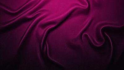 The primary subject of the image is a purple fabric, which is the main object, scene, or focus of the image. The setting or background is a purple curtain, and the visual style is a photo. The colors and mood of the image are predominantly purple, creating a calm and serene atmosphere.
