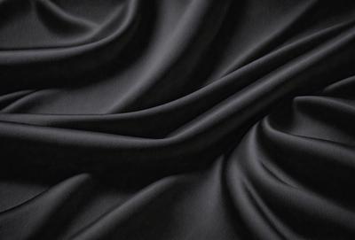The primary subject of the image is a black fabric, which appears to be a piece of cloth or a curtain. The setting is a dark room, and the visual style is a close-up of the fabric. The colors and mood of the image are predominantly dark, with the black fabric being the main focus.