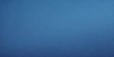 The primary subject of the image is a clear blue sky. The setting is a vast, open space with no visible landmarks or objects. The visual style is a natural, untouched landscape. The colors and mood are serene and peaceful, with the blue sky creating a calm and tranquil atmosphere.