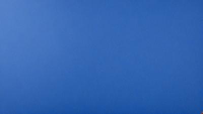 The primary subject of the image is a large, open blue sky. The setting is a vast, cloudless expanse, with no visible landmarks or objects. The visual style is a natural, untouched landscape, with no indication of digital manipulation or artistic elements. The colors and mood are predominantly blue, creating a serene and peaceful atmosphere.