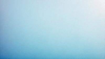 The primary subject of the image is a large, empty blue sky. The setting is a vast, open space with no visible landmarks or objects. The visual style is a natural, outdoor scene with a focus on the sky. The colors and mood are predominantly blue, creating a calm and serene atmosphere.