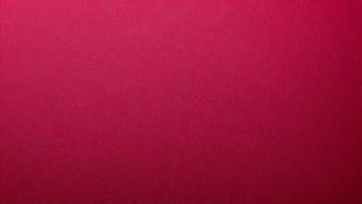 The primary subject of the image is a close-up of a pink surface, which appears to be a piece of leather. The setting is a room with a pink wall, and the visual style is a close-up of the pink surface. The colors and mood of the image are predominantly pink, creating a warm and inviting atmosphere.