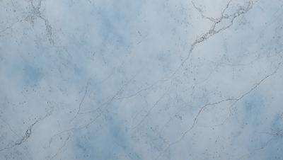 The primary subject of the image is a marble wall with a cracked and chipped appearance. The setting is a room with a blue background. The visual style is a close-up of the marble wall, showcasing its texture and imperfections. The colors and mood of the image are predominantly blue, giving it a calm and serene atmosphere.