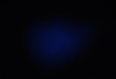 The primary subject of the image is a blue background. The setting is a dark room, and the visual style appears to be a photo. The dominant colors are blue and black, creating a calm and serene atmosphere.