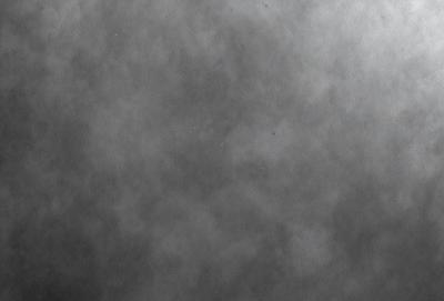 The primary subject of the image is a gray, foggy sky. The setting is a cloudy, overcast day, with the sky serving as the background. The visual style is a black and white photo, which adds a sense of depth and moodiness to the scene. The colors and mood are predominantly dark and moody, with the gray sky and clouds creating a dramatic atmosphere.