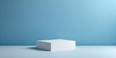 The primary subject of the image is a white box, which is placed on a white surface. The setting is a blue wall, which serves as the background. The visual style of the image is a photo, capturing the white box and the blue wall in a realistic manner. The colors and mood of the image are predominantly white and blue, creating a clean and calm atmosphere.