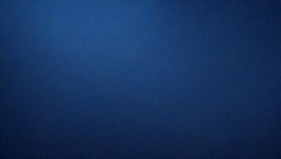 The primary subject of the image is the sky, which is a deep blue color. The setting is a vast, open space with no visible landmarks or objects. The visual style is a natural, outdoor scene. The colors and mood convey a sense of tranquility and calmness.