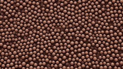 The primary subject of the image is a close-up of a chocolate-covered candy, which is the main focus of the image. The setting is a brown surface, possibly a table or a counter, where the candy is placed. The visual style of the image is a close-up, which emphasizes the details of the candy. The colors in the image are predominantly brown, which is the color of the candy and the surface it is placed on. The overall atmosphere of the image is one of indulgence and enjoyment, as the candy is a popular treat often associated with happiness and pleasure.