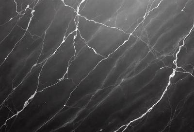 The primary subject of the image is a marble countertop with a black background. The countertop features a pattern of white and black veins, giving it a unique and elegant appearance. The visual style of the image is a close-up of the marble countertop, showcasing its intricate details. The colors and mood of the image are predominantly black and white, creating a sophisticated and timeless atmosphere.