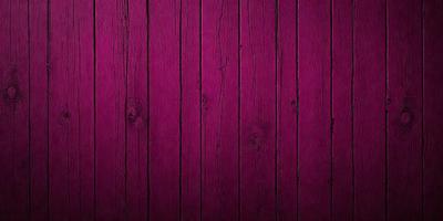 The primary subject of the image is a wooden wall with a purple color. The setting is a room with a wooden floor. The visual style is a close-up of the wooden wall, showcasing its texture and color. The dominant colors are purple and brown, creating a warm and cozy atmosphere.