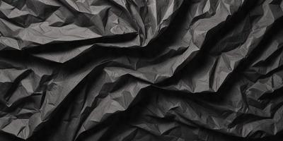 The primary subject of the image is a black and white patterned paper, which appears to be a piece of fabric. The setting is a dark background, which contrasts with the paper's pattern. The visual style is a close-up of the paper, showcasing its intricate design. The colors and mood of the image are predominantly dark, with the paper's pattern providing a sense of depth and texture.