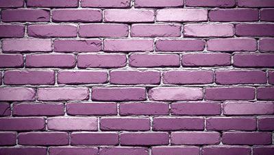 The primary subject of the image is a purple brick wall. The setting is a brick wall, and the visual style is a photo. The dominant colors are purple and pink, creating a warm and inviting atmosphere.