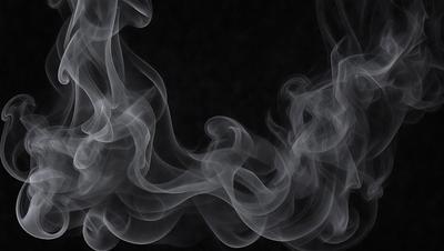 The primary subject of the image is a large, dark, and smoky cloud. The setting is a black background, which contrasts with the cloud, making it stand out. The visual style is a close-up of the cloud, emphasizing its texture and density. The colors and mood of the image are dark and moody, with the cloud appearing ominous and mysterious.