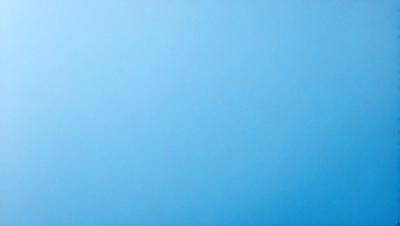 The primary subject of the image is a clear blue sky. The setting is a vast, open space with no visible landmarks or objects. The visual style is a natural, outdoor scene. The colors and mood are predominantly blue, creating a calm and serene atmosphere.