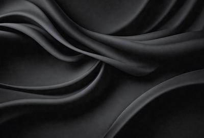 The primary subject of the image is a black fabric, which appears to be a piece of clothing or a curtain. The setting is a dark room, and the visual style is a close-up of the fabric. The colors and mood of the image are predominantly dark and moody, with the black fabric being the main focus.