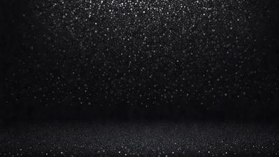 The primary subject of the image is a black background with a pattern of white dots. The setting is a dark room, and the visual style is a close-up of the dots. The colors and mood of the image are predominantly black and white, creating a stark and minimalist atmosphere.
