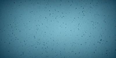 The primary subject of the image is a blue wall with a pattern of white specks. The setting is a room with a blue background. The visual style is a close-up of the blue wall with white specks. The colors and mood of the image are predominantly blue and white, creating a calm and serene atmosphere.