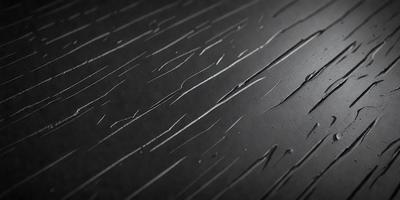 The primary subject of the image is a black surface with white streaks, which appears to be a painting or a drawing. The setting is a black background, and the visual style is a close-up of the artwork. The colors and mood of the image are predominantly black and white, creating a dramatic and artistic atmosphere.