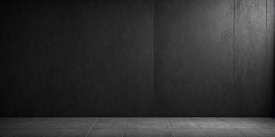 The primary subject of the image is a large, dark grey wall. The setting is a room with a concrete floor. The visual style is a photo, and the dominant colors are grey and black. The overall atmosphere is dark and moody.