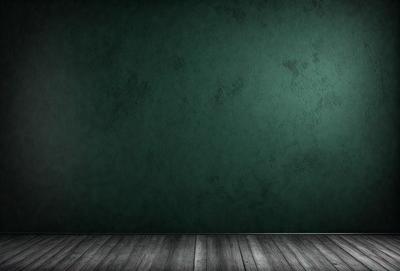 The primary subject of the image is a green wall with a wooden floor. The setting is a room with a green wall, and the visual style is a photo. The colors and mood of the image are predominantly green, creating a calm and serene atmosphere.