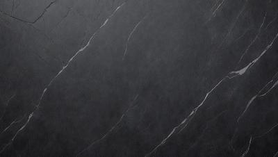 The primary subject of the image is a black marble countertop. The setting is a kitchen, with the countertop being the main focus of the scene. The visual style is a close-up of the marble countertop, showcasing its texture and details. The colors and mood of the image are predominantly dark, with the black marble countertop being the main source of contrast and visual interest.