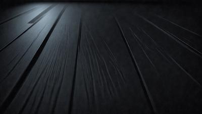 The primary subject of the image is a wooden floor with a black background. The setting appears to be a dark room, possibly a hallway or a room with a black floor. The visual style of the image is a close-up of the wooden floor, which gives it a textured and detailed appearance. The colors in the image are predominantly black, creating a moody and dramatic atmosphere.
