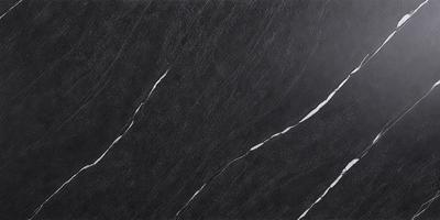 The primary subject of the image is a black marble countertop. The setting is a kitchen, with the countertop being the main focus of the scene. The visual style is a close-up of the marble countertop, showcasing its texture and details. The colors and mood of the image are predominantly dark, with the black marble countertop being the main source of contrast and visual interest.