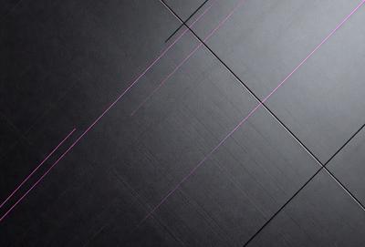 The primary subject of the image is a black surface with a pink line running through it. The setting appears to be a room with a black floor. The visual style of the image is a close-up of the black surface with the pink line. The colors and mood of the image are predominantly black and pink, creating a contrasting and visually striking scene.