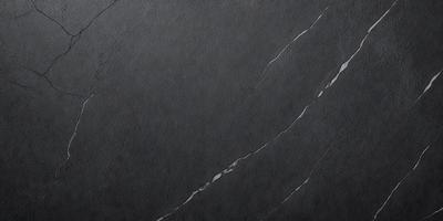 The primary subject of the image is a black marble countertop. The setting is a kitchen, with the countertop being the main focus of the scene. The visual style is a photo, capturing the marble countertop's texture and appearance. The colors in the image are predominantly black, giving the countertop a sleek and modern look.