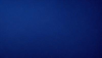 The primary subject of the image is a large, open, and dark blue sky. The setting is a vast, empty space with no visible landmarks or objects. The visual style is a simple, unadorned representation of the sky, with no additional elements or textures. The colors and mood of the image are predominantly dark and moody, with the deep blue of the sky creating a sense of vastness and emptiness.