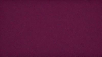 The primary subject of the image is a close-up of a maroon-colored surface. The setting is a dark room, and the visual style appears to be a photo. The dominant colors in the image are maroon and dark, creating a moody atmosphere.