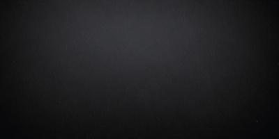 The primary subject of the image is a black background. The setting is a dark, empty space with no visible objects or elements. The visual style is a black and white photo, which gives the image a classic and timeless appearance. The colors and mood are predominantly dark and moody, creating a sense of mystery and depth.