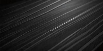 The primary subject of the image is a thin line, which is the main focus of the scene. The setting is a black background, and the visual style appears to be a pattern or texture. The colors in the image are predominantly black, creating a moody atmosphere.
