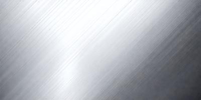 The primary subject of the image is a silver metal surface, which appears to be a metal wall or a metal sheet. The setting is a room with a white background, which contrasts with the silver metal surface. The visual style is a close-up of the metal surface, showcasing its texture and reflective properties. The colors and mood of the image are predominantly silver and white, creating a clean and modern atmosphere.