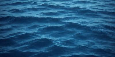 The primary subject of the image is a large body of blue water, which appears to be a deep ocean. The setting is a vast expanse of water, with no visible land or other objects. The visual style is a realistic representation of the ocean, with no indication of digital manipulation or artistic elements. The colors and mood of the image are predominantly blue, creating a serene and tranquil atmosphere.