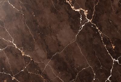 The primary subject of the image is a marble tile with a brown and gold color scheme. The setting is a bathroom, and the visual style is a close-up of the tile. The colors and mood of the image are warm and elegant, with the marble tile adding a touch of luxury to the bathroom.