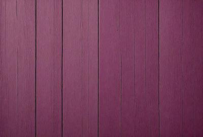 The primary subject of the image is a purple wooden wall. The setting is a room with a purple wooden wall, which serves as the background. The visual style is a close-up of the purple wooden wall, showcasing its texture and color. The dominant colors are purple and brown, creating a warm and inviting atmosphere.