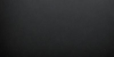 The primary subject of the image is a black background. The setting is a dark room, and the visual style is a black and white photo. The colors and mood of the image are dark and moody, creating a sense of mystery or drama.