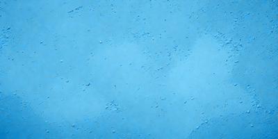 The primary subject of the image is a blue surface, which appears to be a wall or a piece of artwork. The setting is a room with a blue background, and the visual style is a close-up of the blue surface. The colors and mood of the image are predominantly blue, creating a calm and serene atmosphere.