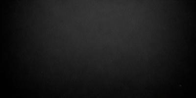 The primary subject of the image is a black background. The setting is a dark, empty space with no visible objects or elements. The visual style is a black and white photo, which gives the image a classic and timeless appearance. The colors and mood are predominantly dark and moody, creating a sense of mystery and depth.