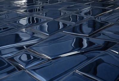 The primary subject of the image is a blue tile floor with a patterned design. The setting is a room with a blue tile wall, and the visual style is a close-up of the tile floor. The colors and mood of the image are predominantly blue, creating a calm and serene atmosphere.