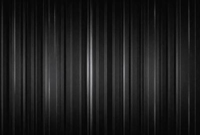 The primary subject of the image is a black and white striped pattern. The setting is a black background, and the visual style is a pattern. The dominant colors are black and white, and the overall atmosphere is bold and striking.