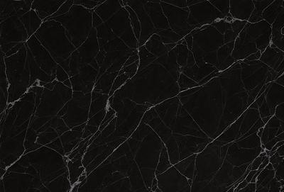 The primary subject of the image is a black marble countertop. The setting is a kitchen, with the countertop being the main focus of the scene. The visual style is a close-up of the marble countertop, showcasing its texture and pattern. The colors and mood of the image are predominantly black, giving it a sleek and modern appearance.