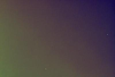 The primary subject of the image is a star, which is located in the middle of the scene. The setting is a dark, cloudy sky, with no visible landmarks or other objects. The visual style appears to be a photo, as it captures the star in its natural environment. The colors and mood of the image are predominantly dark and moody, with the star being the only bright and prominent feature in the scene.