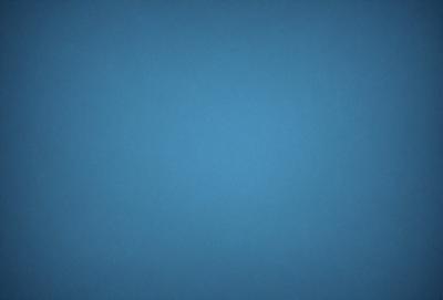 The primary subject of the image is a large, open, and empty blue sky. The setting is a vast, cloudless expanse, with no visible landmarks or objects. The visual style is a natural, untouched landscape, with no indication of digital manipulation or artistic elements. The colors and mood are predominantly blue, conveying a sense of tranquility and vastness.
