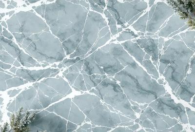 The primary subject of the image is a marble wall with a patterned texture. The setting is a room with a marble floor, and the visual style is a close-up of the marble wall. The colors and mood of the image are predominantly gray, giving it a sophisticated and elegant appearance.