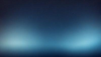 The primary subject of the image is a blue sky with a few clouds. The setting is a vast, open space with no visible landmarks or objects. The visual style is a photo, capturing the beauty of the sky and clouds. The colors and mood are predominantly blue, creating a serene and peaceful atmosphere.